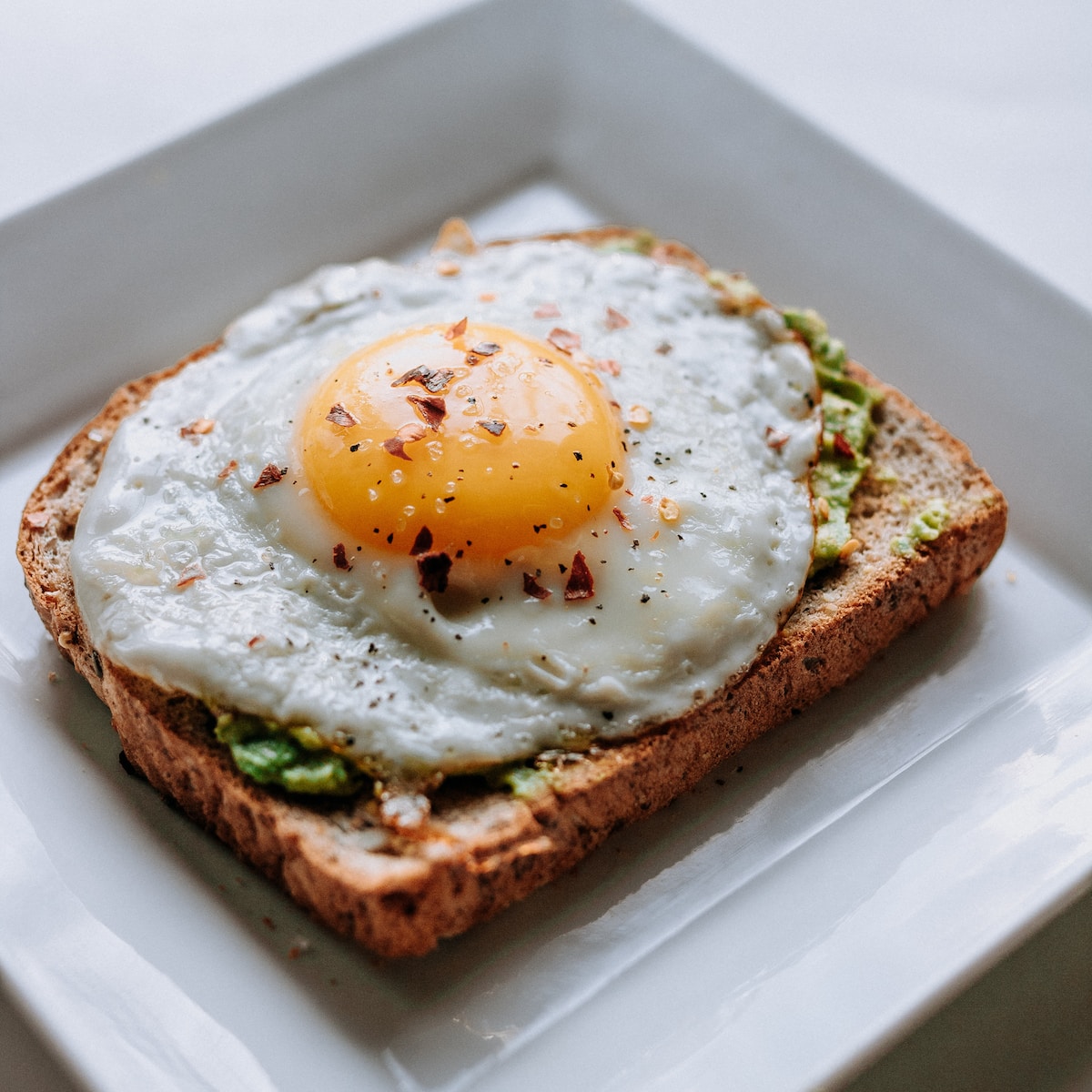 hangover bread with sunny side-up egg served on white ceramic plate