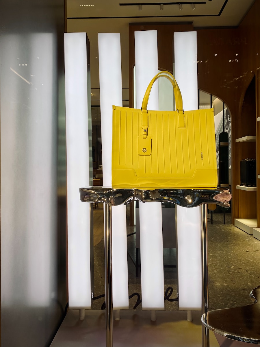 luxury purses a yellow bag on a white stand