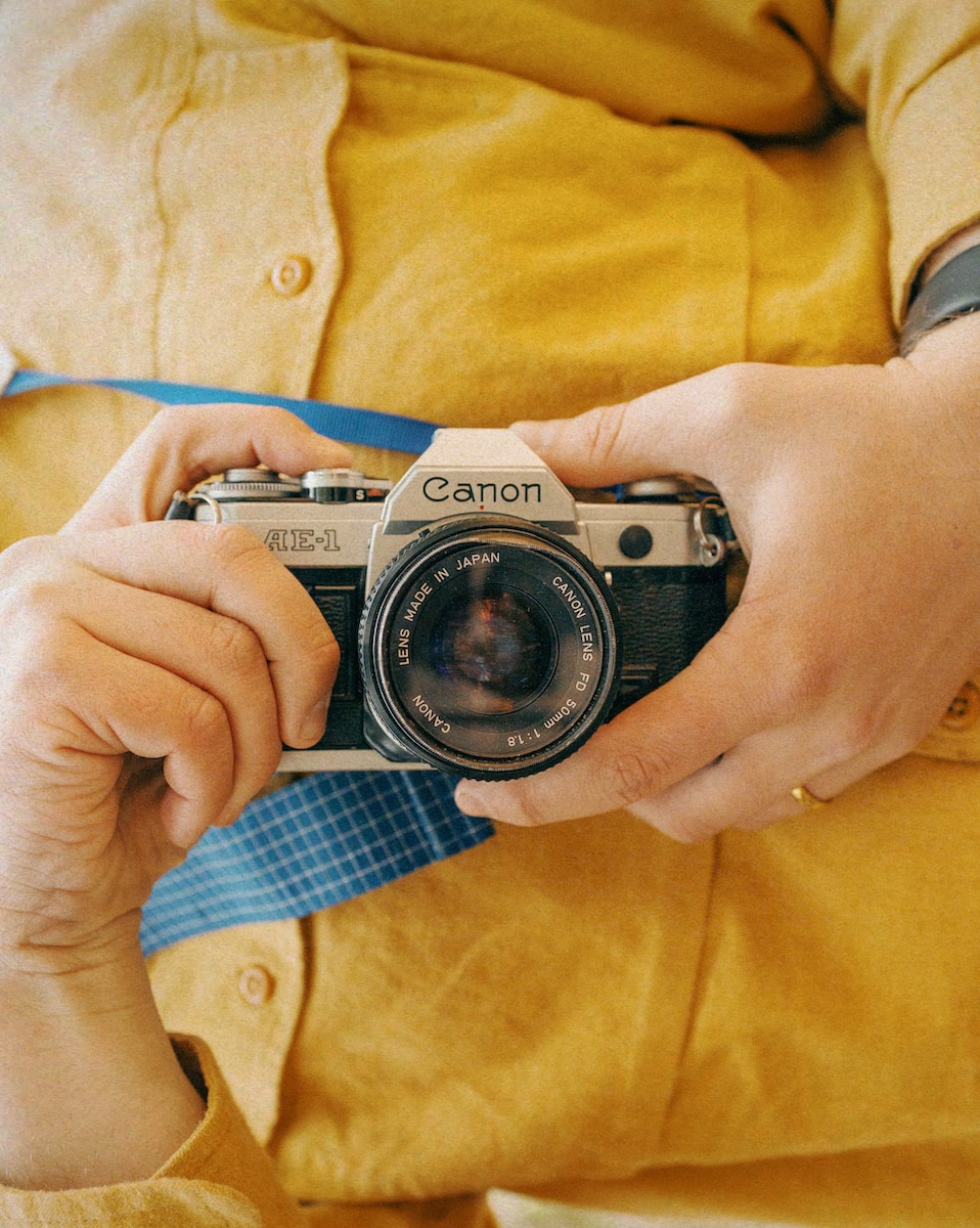 Canon AE-1 a person holding a camera in their hands