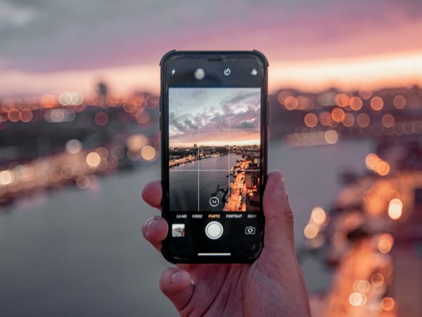 flip phones person holding black iphone 5 taking photo of city during sunset